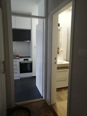 a kitchen with white cabinets and a sink and a stove at Green 1 in Belgrade