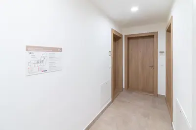 a hallway with a door and a sign on the wall at Belgrade Waterfront Studio Apartment-Supertwins in Sajmište