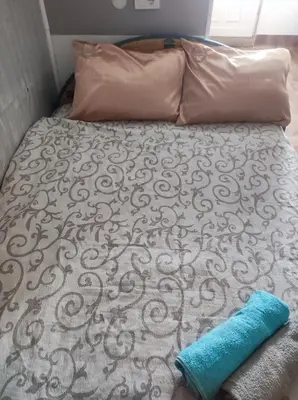 a bed with a pillow and a blue towel on it at Stan na dan studio in Inđija