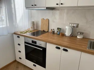 a kitchen with white cabinets and a stove top oven at Hidden Gem in Belgrade