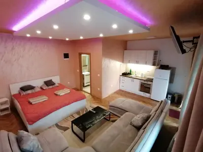 a room with a bed and a couch and a kitchen at Pelegrino in Stara Pazova