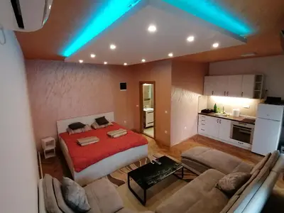 a room with a bed and a couch and a kitchen at Pelegrino in Stara Pazova