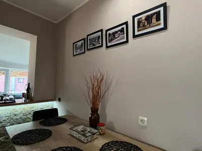 a dining room with a table and some pictures on the wall at Apartman Stojanović in Arandjelovac