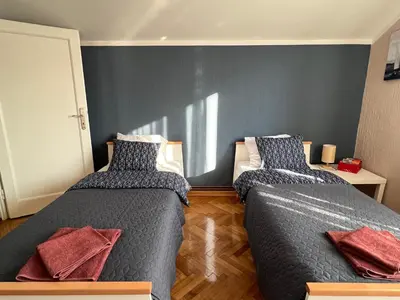 a bedroom with two beds and a blue wall at Apartman Stojanović in Arandjelovac