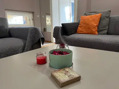 a living room with a table with a bowl of flowers at Apartman Stojanović in Arandjelovac