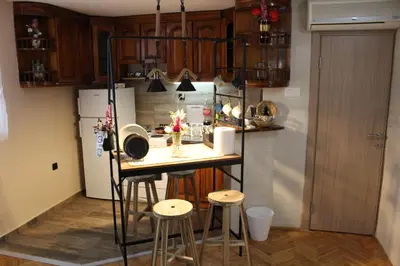 a small kitchen with a table and some stools at Apartman AS in Belgrade