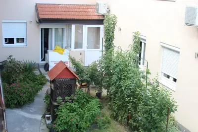 a garden in front of a building with a house at Apartman AS in Belgrade