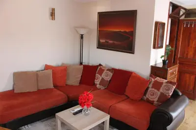a living room with a red couch and a table at Apartman AS in Belgrade