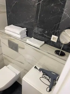 a bathroom with a white toilet and a mirror at Princess - free parking place in the garage in Belgrade