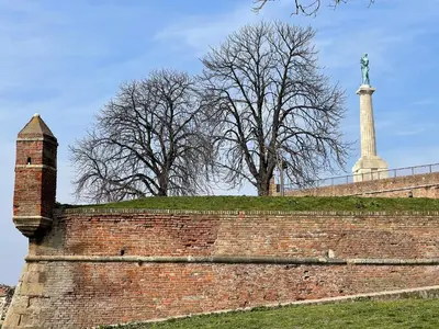 a brick wall with a statue in the background at Princess - free parking place in the garage in Belgrade