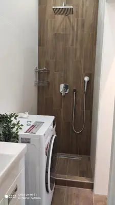 a small bathroom with a shower with a washer at Zone Vidikovac in Belgrade