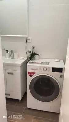 a washing machine in a kitchen next to a sink at Zone Vidikovac in Belgrade