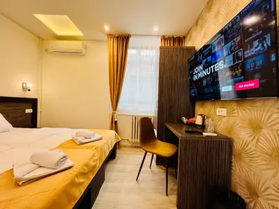 a hotel room with a bed and a flat screen tv at Side One Design Hotel Garni in Belgrade
