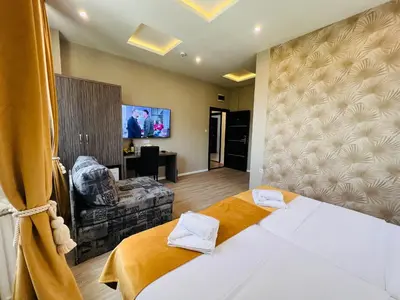 a hotel room with a bed and a living room at Side One Design Hotel Garni in Belgrade