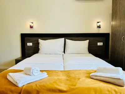 a bedroom with a bed with two towels on it at Side One Design Hotel Garni in Belgrade