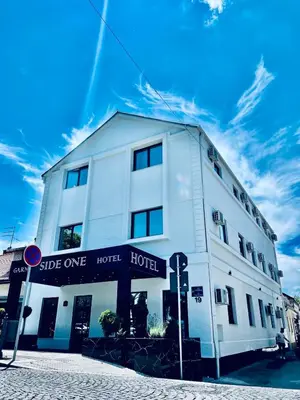 a white building on the corner of a street at Side One Design Hotel Garni in Belgrade