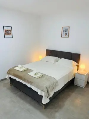 a bedroom with a large bed with two towels on it at Muki apartments in Surčin