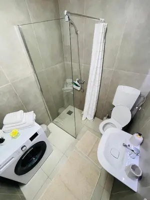 a bathroom with a shower and a toilet and a sink at Muki apartments in Surčin