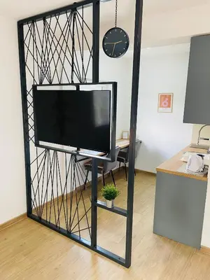 a flat screen tv on a stand in a room at Muki apartments in Surčin