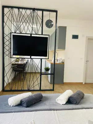 a room with a flat screen tv and two pillows on a bed at Muki apartments in Surčin