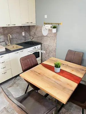 a kitchen with a wooden table and chairs at Muki apartments in Surčin