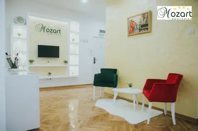 a room with two chairs and a table and a tv at Mozart-Apartman in Arandjelovac