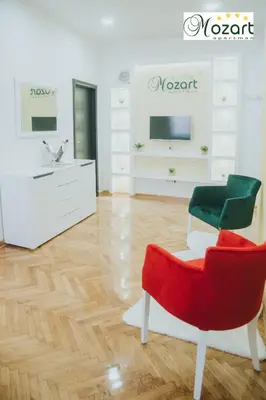 a living room with a red chair and a couch at Mozart-Apartman in Arandjelovac