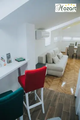 a living room with a red chair and a couch at Mozart-Apartman in Arandjelovac