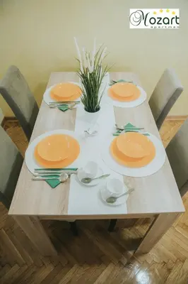 a wooden table with four plates on it at Mozart-Apartman in Arandjelovac