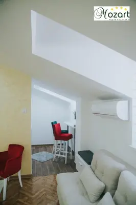 a living room with a white couch and red chairs at Mozart-Apartman in Arandjelovac