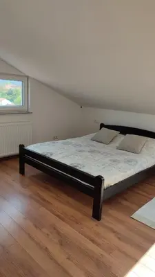 a large bed in a room with a window at Apartman Lena in Arandjelovac