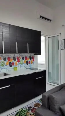 a kitchen with black cabinets and a white counter top at Apartman Lena in Arandjelovac