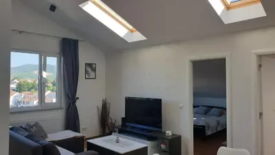 a living room with a couch and a flat screen tv at Apartman Lena in Arandjelovac