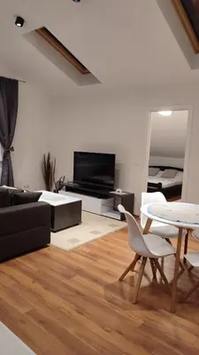a living room with a television and a table and chairs at Apartman Lena in Arandjelovac