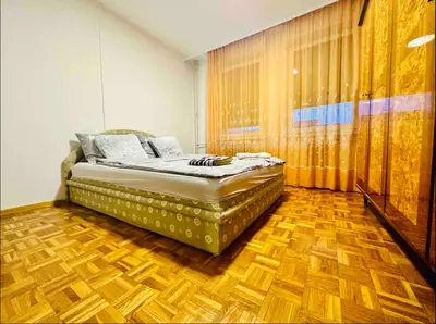 a bedroom with a bed and a wooden floor at Blok in Sajmište