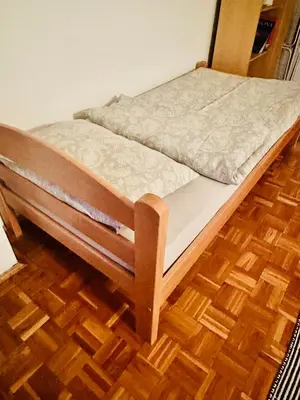 a bed sitting on top of a wooden floor at Blok in Sajmište