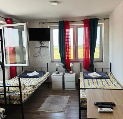 a room with two beds and a table and two windows at Motel Gas in Belgrade