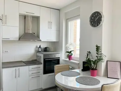 a kitchen with a table and a clock on the wall at Cozy nest SAVADA in Belgrade