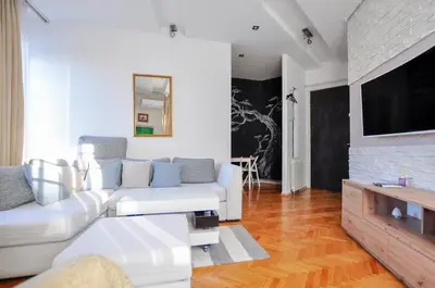 a living room with a white couch and a flat screen tv at Heart of Belgrade Skadarlija Apartment in Belgrade
