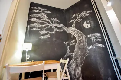 a chalkboard wall with a tree mural in a dining room at Heart of Belgrade Skadarlija Apartment in Belgrade