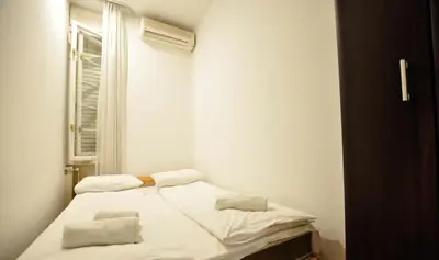 a small white room with a bed and a window at Heart of Belgrade Skadarlija Apartment in Belgrade