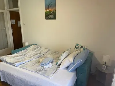 a bed in a bedroom with a picture on the wall at Apartman CENTAR in Titel