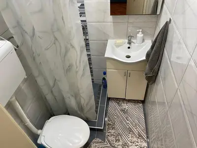 a small bathroom with a toilet and a sink at Apartman CENTAR in Titel