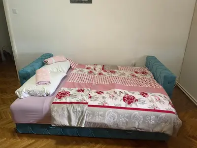 a bed in a room with a bedspread on it at Apartman CENTAR in Titel