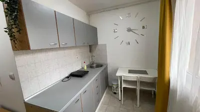 a kitchen with a clock on the wall and a sink at Voždovac Vitanovacka in Belgrade
