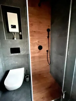a bathroom with a toilet and a wooden floor at Vinceia in Smederevo