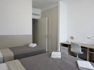 a hotel room with two beds and a desk and a chair at Premium NB Apartment - Belgrade Waterfront in Belgrade