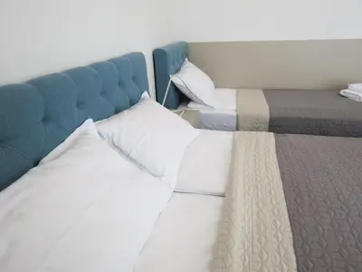 a bed with white sheets and a blue headboard at Premium NB Apartment - Belgrade Waterfront in Belgrade