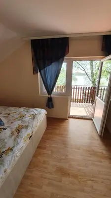 a bedroom with a bed and a large window at Vila Marina in Kovin