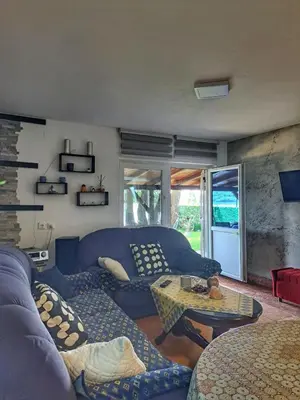 a living room with a blue couch and a table at Vila Marina in Kovin